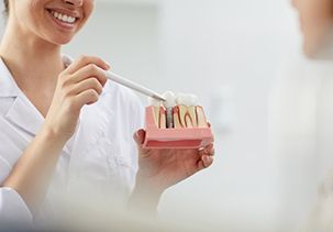 a dentist explaining how dental implants work to a patient 