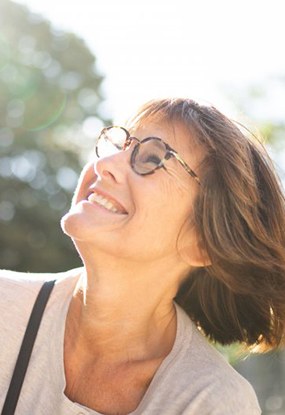 an older woman smiling while outside