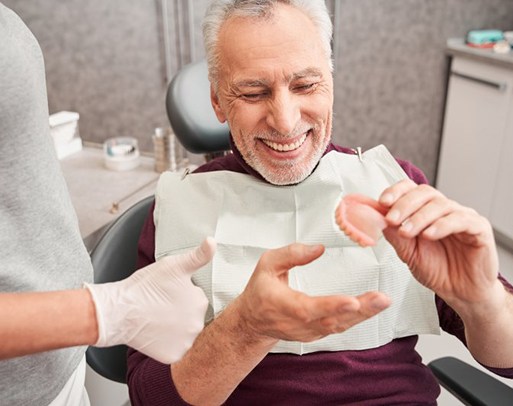 a patient smiling while getting his new denture