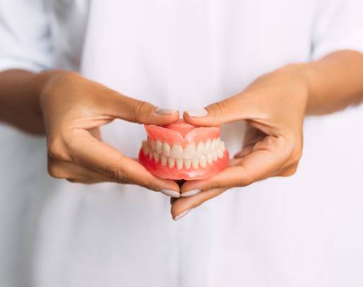 a person holding a full denture