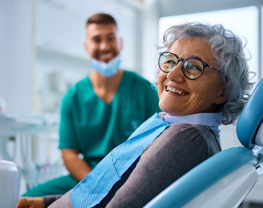 a patient smiling while wearing her new dentures